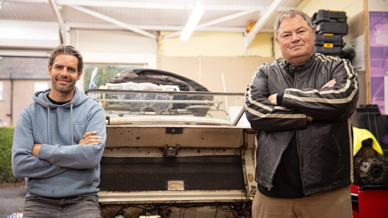 Mike Brewer & Marc ‚Elvis‘ Priestley Standing with a white Hillman IMP – Bild: Warner Bros. Discovery