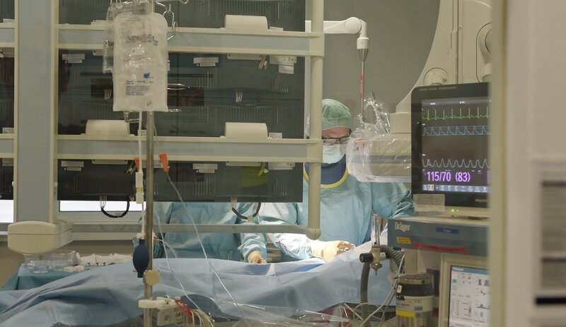 Konzentrierte Arbeit im OP: Während der Monitor stabile Werte anzeigt, operiert das Team unter sterilen Bedingungen. – Bild: me:works /​ ZDF