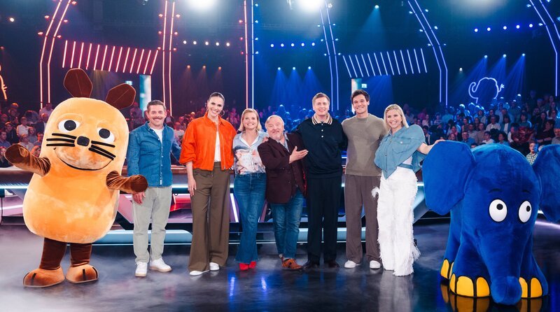 Eingerahmt von Maus und Elefant: v.l.n.r. Klaas-Heufer-Umlauf, Esther Sedlaczek, Annette Frier, Axel Prahl, Till Reiners, Wincent Weiss und Beatrice Egli bei der Jubiläumsausgabe zum 20-jährigen Bestehen der großen Maus-Show – Bild: WDR/​Ben Knabe