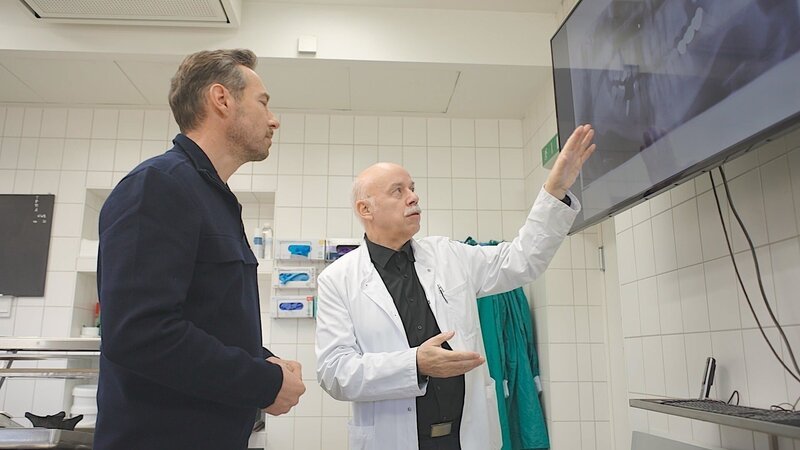 Sven Voss lässt sich von Rechtsmediziner Dr. Rüdiger Lessig erklären, welche Rolle Zähne bei der Identifizierung unbekannter Toter spielen. – Bild: ZDF