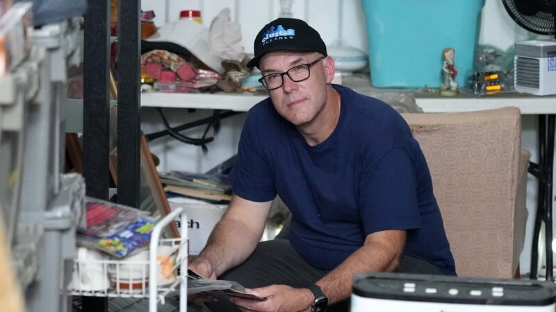 Mike Kelleher posing in client’s hoarded storage container – Bild: Warner Bros. Discovery