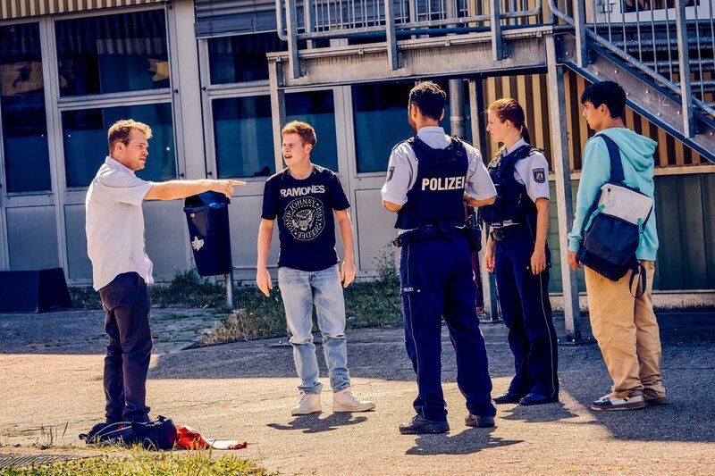 Ernst (Diyar Ilhan, r.) hat vor Eifersucht die Polizei auf Julian (Ben Münchow, l.) gehetzt mit der Behauptung, Julian habe Janniks (Leon Siedel, 2.v.l.) Fahrrad alleine beschädigt. Jannik, der Julian bis eben noch für seinen Vater hielt, ist nun vollkommen verwirrt. – Bild: Frank Dicks /​ ZDF
