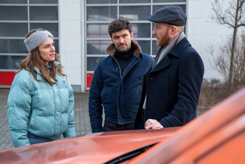 Autohausbesitzer Jens Ehrenberg (Lukas Turtur, r.) beschwert sich bei Lucy (Josephin Busch) und Alexander (Aleksandar Radenković, M.) über Randalierer, die letzte Nacht seine Autos besprüht hätten. – Bild: Oliver Feist /​ ZDF