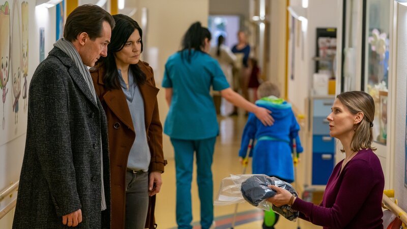 Radek (Hans-Werner Meyer, l.) und Mina (Jasmin Tabatabai, M.) überreichen der besorgten Janina (Katrin Röver, r.) den Schlafanzug ihres Sohnes, der aus dem Krankenhaus verschwunden ist. – Bild: ZDF