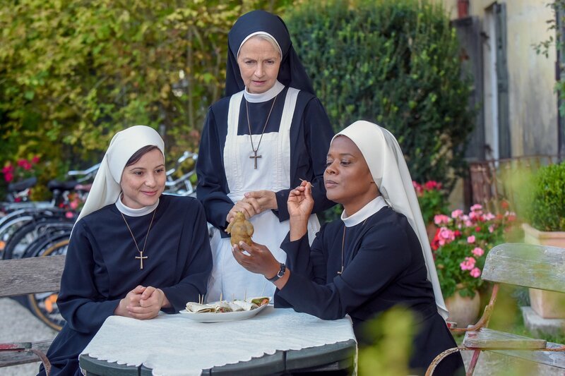 Schwester Lela piekst den Kartoffel-Wöller mit einem Zahnstocher (v.li.: Mareike Lindenmeyer, Emanuela von Frankenberg, Denise M’Baye). – Bild: ORF 2