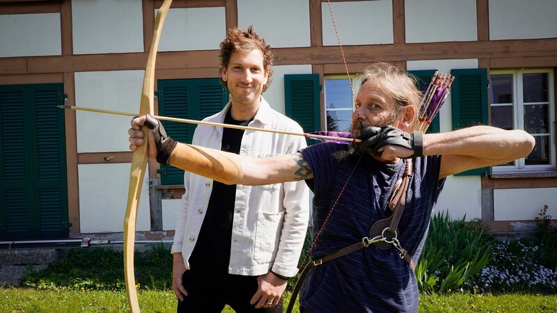 Reporter Spezial – Donat auf Achse: Von Kindheitstraumas, ESC-Stars und Raubkunst, Folge 5. Donat (l.) und Chrigu (r.), der als Hobby Pfeilbogen schiesst. – Bild: SRF/​René Alfeld