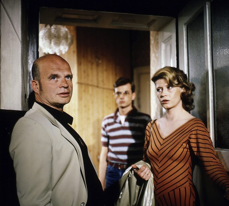 Nichtsahnend betritt Gudrun Kaul (Lisa Kreuzer) ihre Wohnung – mit dem ungebetenen Besuch von Walter Buschmann (Peter Kuiper, l.), dem Vater ihres 10jährigen Sohnes, hat sie nicht gerechnet. Im Hintergrund: Student und Untermieter Ulrich Steinnitz (Hans-Jürgen Schatz). – Bild: ZDF /​ Michael Marhofer