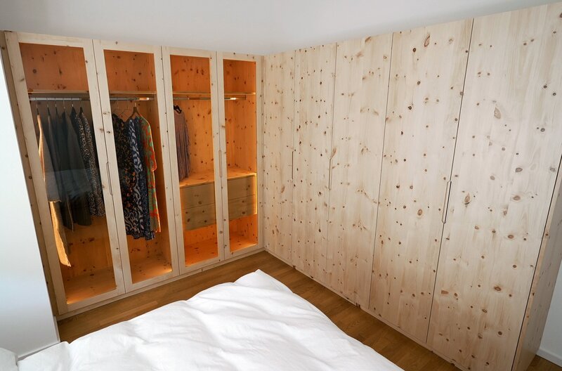 Der beleuchtete Kleiderschrank aus Zirbenholz über Eck mit Boutique-Schrank und Alltagsschrank. – Bild: SWR