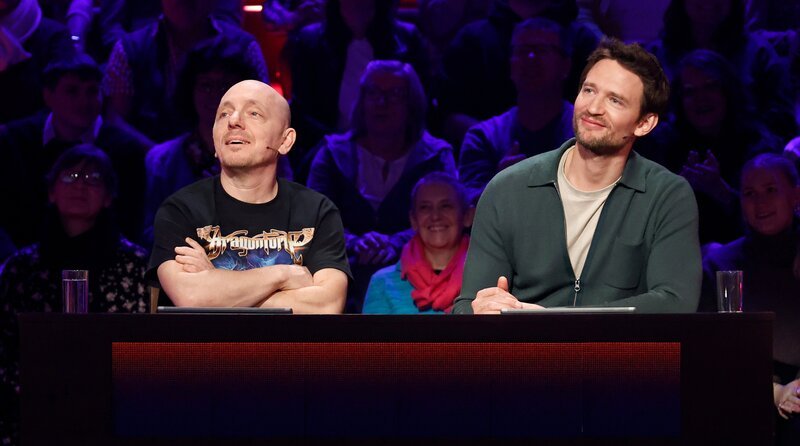 Rateteam-Kapitän Bernhard Hoëcker (l.) mit Schauspieler August Wittgenstein (r.). – Bild: ARD/​Morris Mac Matzen