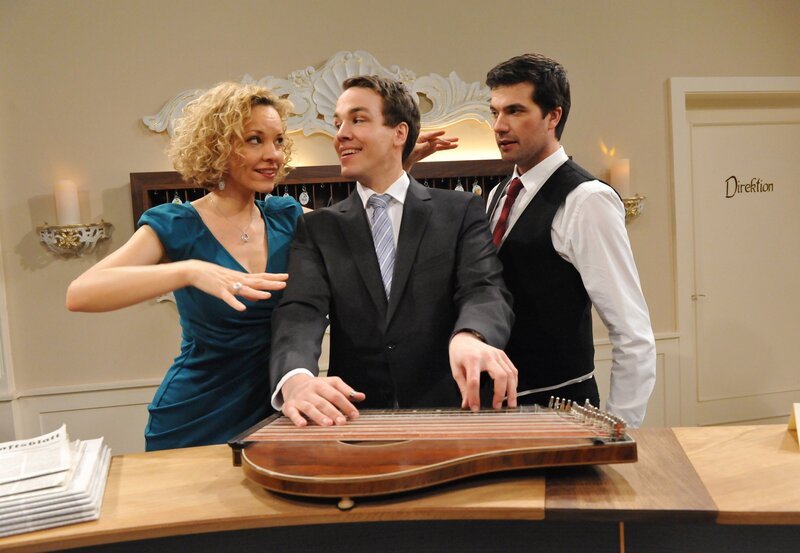 Natascha (Melanie Wiegmann, l.) und Konstantin (Moritz Tittel, r.) feuern Xaver (Jan van Weyde, M.) an der Zither an. – Bild: ARD/​Ann Paur