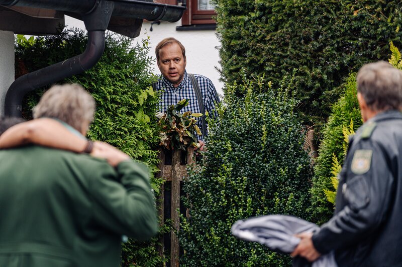 Hubert (Christian Tramitz, r.) und Girwidz (Michael Brandner, l.) befragen den Nachbarn Heinz Mischmeier (David Baalcke, M.). Weiß er, wer hier im Haus wohnt? – Bild: Leonine /​ Wunderland Media UG
