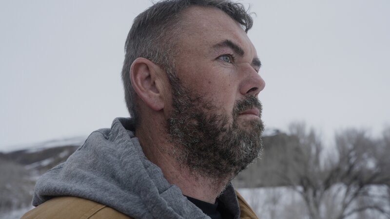 Close-up of contributor Jeremy MacDonald, friend of Dave & Steph Jackson, shot from the left side looking away from camera. Background out of focus behind him. Exterior, landscape. – Bild: Warner Bros. Discovery, Inc. or its subsidiaries and affiliates