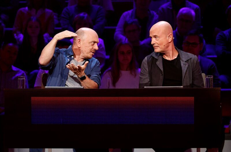 Rateteam-Kapitän Bernhard Hoëcker (l.) und der Schauspieler Christian Berkel (r.) versuchen gemeinsam, die richtige Antwort zu finden. – Bild: ARD/​Morris Mac Matzen