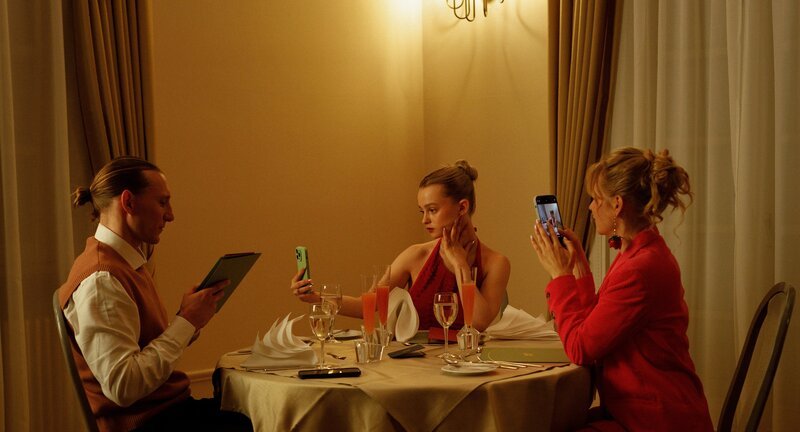Familie Sommer sitzt in Abendgarderobe an einem Tisch in einem gehobenen Restaurant. Von links: Chris (Liliom Lewald), Luca (Maja Bons) und Stella (Bea Brocks) – Bild: Jakob Fliedner /​ ZDF und Jakob Fliedner