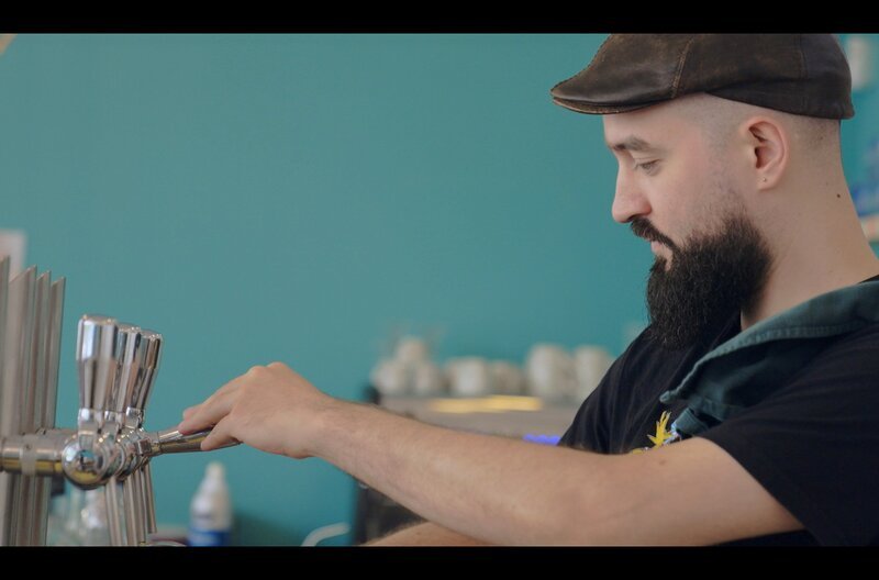 Lou zapft ein Bier. In Bordeaux betreibt er ein Café. Die Vorstellung, in der heutigen Welt Kinder zu bekommen, ist für ihn auch beängstigend. – Bild: Maximal Productions