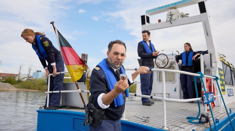 Maike (Carina Wiese, l.), Jana (Barbara Prakopenka, r.) und Moritz (Ferdi Özten, 2.v.r.) überprüfen das Schiff. Sami (Adnan Maral, 2.v.l.) findet den mutmaßlichen Verursacher der Delle am Geräteträger – einen Bergemagneten. – Bild: ARD/​Rudolf Wernicke