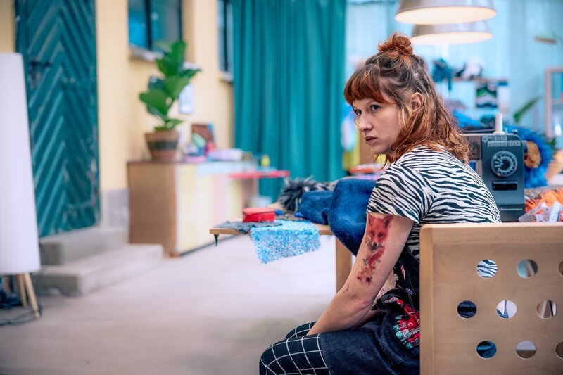 Emily Fuchs (Marlene Hauser) sitzt an der Nähmaschine in ihrer Werkstatt. – Bild: ORF/​Mona Film/​Fabio Eppensteiner
