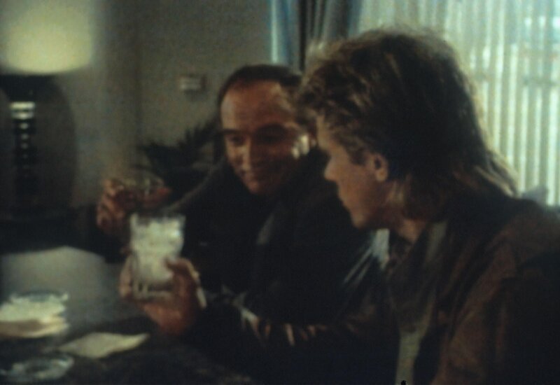 MacGyver (Richard Dean Anderson, r.) soll einen gewissen Simmons aufspüren. Seine Ermittlungen führen ihn in eine Bar, wo er auf den Killer Kendall (Joe Santos, l.) trifft, der sich als dessen Vater ausgibt … – Bild: Paramount Pictures