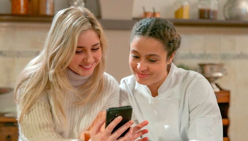 Toni (l. Sarah Buchholzer) fotografiert Ellie (r. Kim Biebow) für eine Werbekampagne im Carlas. Dabei knistert es immer mehr zwischen den beiden Frauen. – Bild: NDR