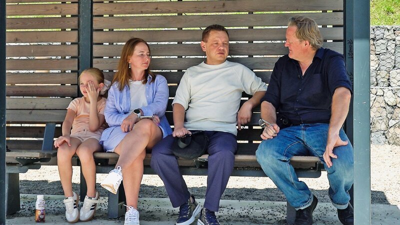 Reporter Christof Franzen (r.) mit der Familie von Alexander Krinizkij (2.v.r.), Frau Nina (2.v.l.) und Tochter Milana (l.) – Bild: SRG SSR
