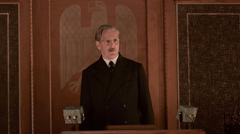 Anno (Jens Harzer) steht am Rednerpult des Reichstags. – Bild: Frédéric Batier/​X Filme Creative Pool/​ARD Degeto Film/​WDR/​SWR/​HR/​Radio Bremen/​Beta Film