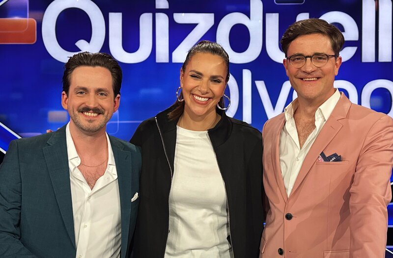 Moderatorin Esther Sedlaczek (M.) mit den Kandidaten des Teams „Bühne“: Marti Fischer (l.) und Bodo Wartke (r.). – Bild: ARD/​ITV Studios