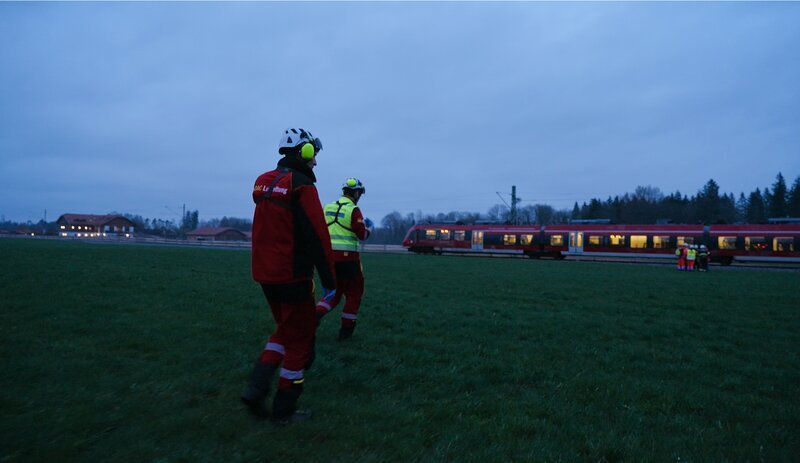 Einsatz in der Dämmerung: Zwei Notärzte gehen auf einen stehenden Zug zu, nachdem eine Person erfasst worden sein soll. – Bild: ZDF und me:wirks
