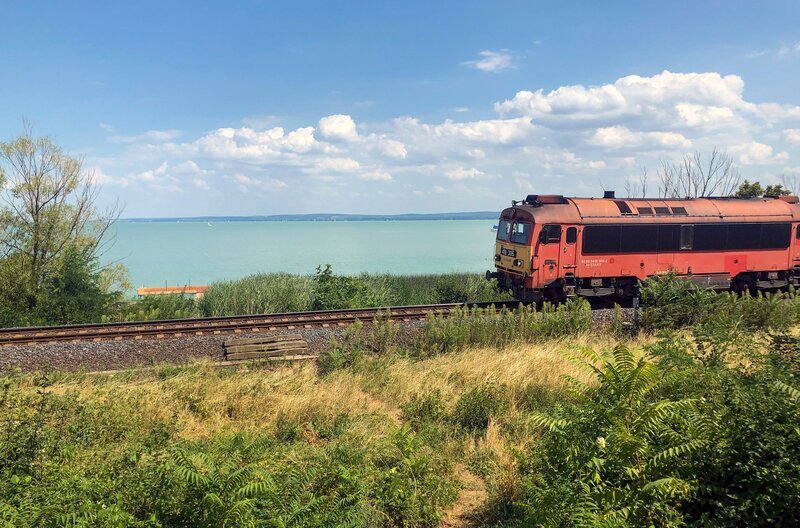 Nördlich des Plattensees verläuft die Bahnlinie teilweise direkt am Ufer. – Bild: SWR/​Alexander Schweitzer