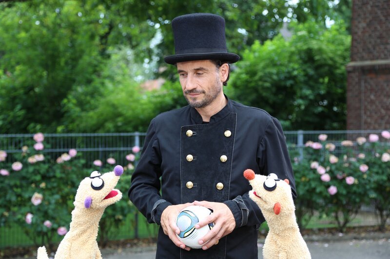 Der Schornsteinfeger (Oliver Mommsen) legt die Erdmännchen rein. – Bild: NDR/​bigSmile