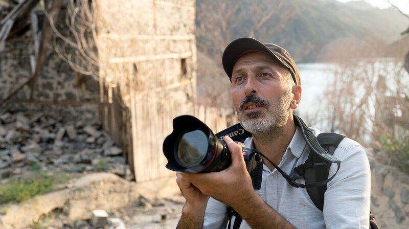 Murat zu Besuch in Yusufeli. Hier sind ganze Dörfer einem Staudamm zum Opfer gefallen. Murat setzt sich als Aktivist dafür ein, das am Highway D915 zu verhindern. – Bild: NDR/​Alexander Hick
