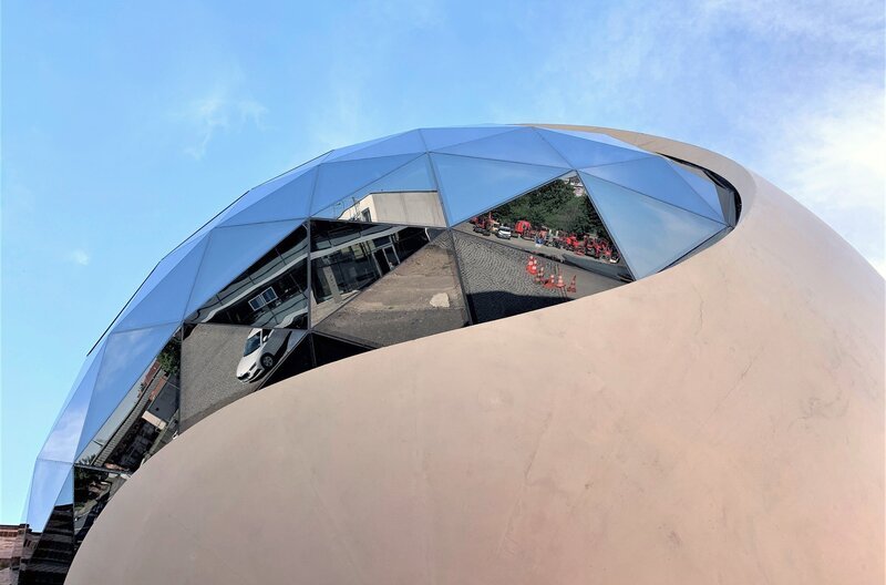 Mit ihren schwungvollen Rundungen bringt die Bauskulptur von Oscar Niemeyer ein Stück brasilianische Leichtigkeit ins Industriegebiet von Leipzig-Neulindenau. – Bild: BR/​Sabine Reeh