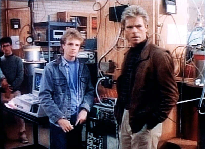 David Ryman (Andrew Sabiston, l.) und MacGyver (Richard Dean Anderson, r.) beobachten, wie Professor Ryman ein Leck in einer Leitung abdichtet. – Bild: Kabel Eins Classics