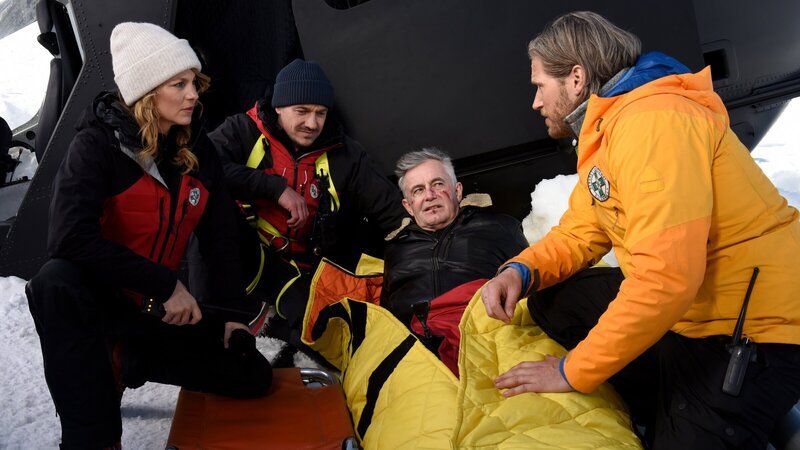 Die Bergretter Katharina (Luise Bähr, l.), Tobi (Markus Brandl, 2.v.l.) und Markus (Sebastian Ströbel, r.) sind froh, ihren Kollegen Michi (Robert Lohr, 2.v.r.) verletzt, aber lebend, gefunden zu haben. – Bild: ZDF