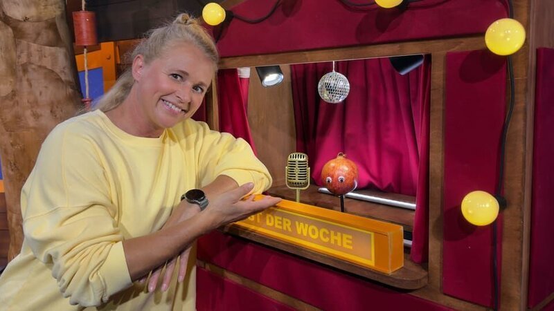 Gitta Granatapfel möchte Obst der Woche werden. Sie zeigt Singa, welche besonderen Kerne sie hat. – Bild: KiKA