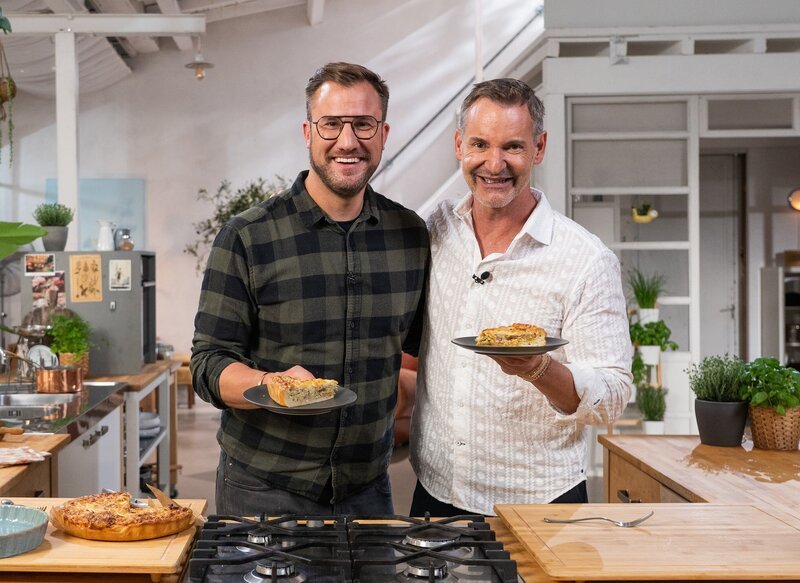 Sören Anders (li.) und Christian Henze freuen sich auf die Quiche Lorraine, die Sören zubereitet hat. – Bild: SWR/​2 Bild GmbH