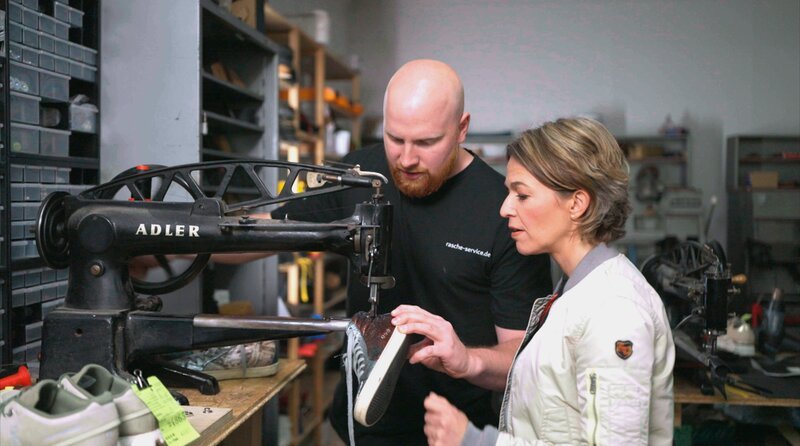 Moderatorin Anna Planken bei Schuhmacher Patrick Rasche, der sich auf Sneaker-Reparatur spezialisiert hat. – Bild: WDR/​Sagamedia/​Sylvia Freudenberger