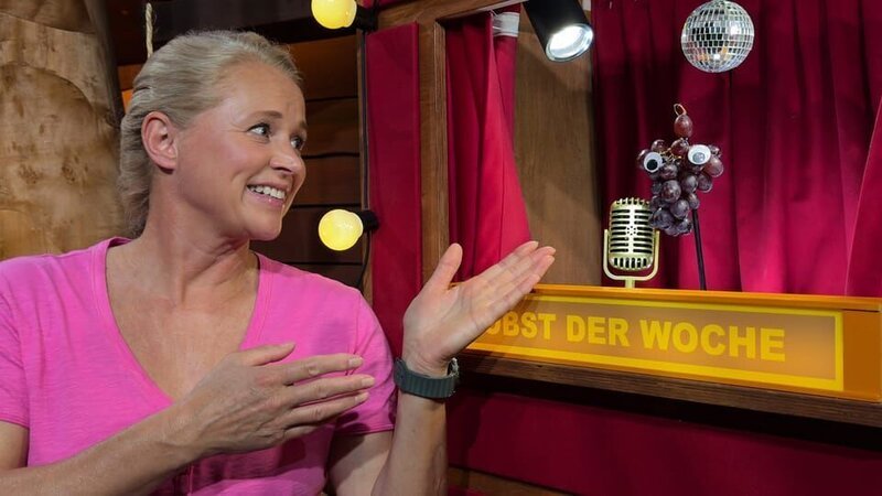 Singa lernt Theo Traube kennen. Er erzählt, warum eine Traube aus vielen Beeren besteht und was grüne und dunkle Trauben unterscheidet. – Bild: KiKA