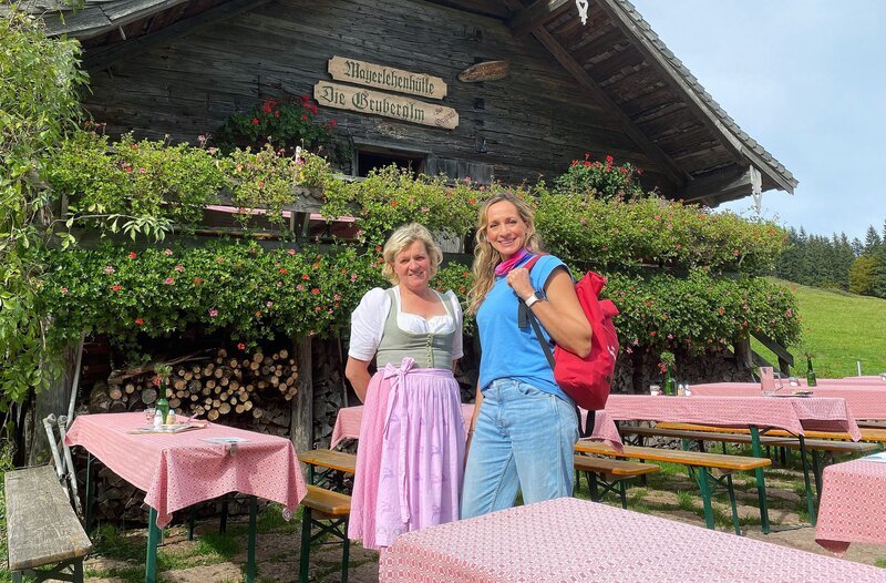 Moderatorin Tamina Kallert (r.) und die Sennerin Lisi Matieschek an der Mayerlehenhütte auf der Gruberalm. – Bild: WDR/​Beate Höfener