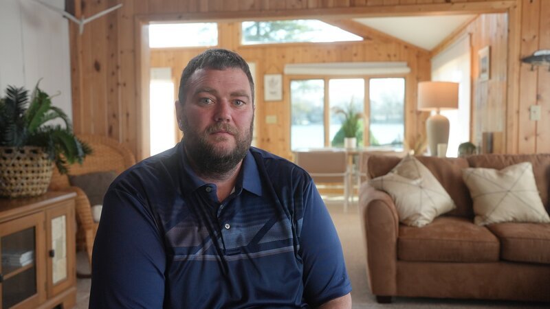 Contributor Jayson Rumball, former employee of Kevin Boyd Sr. looking at camera during his interview. Tattoo visible on his lower right arm. Interior, landscape – Bild: Warner Bros. Discovery, Inc. or its subsidiaries and affiliates