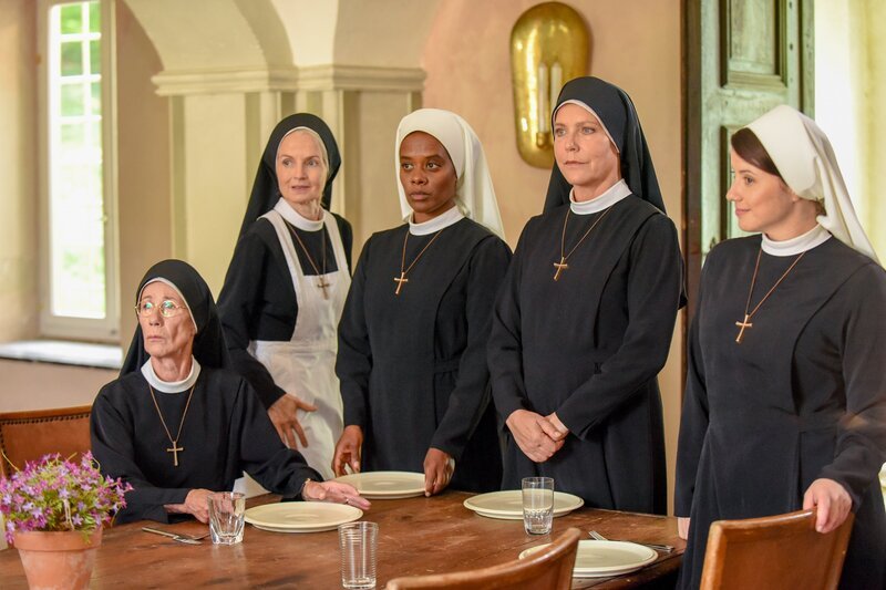 Gloria/​Schwester Sina wird vorgestellt und soll im Kloster bleiben (v.li.: Karin Gregorek, Emanuela von Frankenberg, Denise M’Baye, Janina Hartwig, Mareike Lindenmeyer). – Bild: ORF 2