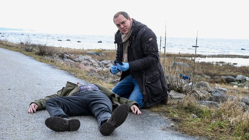 Thomas (Andy Gätjen) untersucht den Toten (Ville Norberg): wurde dieser erschossen, als in sein Haus eingebrochen wurde? – Bild: SRF/​ZDF/​Marion von der Mehden