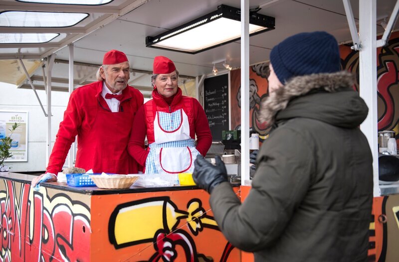 Theo (Frederic Böhle, r.) ist von seinem Marketing-Seminar zurück und steht verblüfft vor dem neuen „American Diner“-Auftritt seiner Wurstbude, den sich Inge (Peggy Lukac, M.) und Hannes (Claus Dieter Clausnitzer, l.) ausgedacht haben. – Bild: ARD/​Nicole Manthey