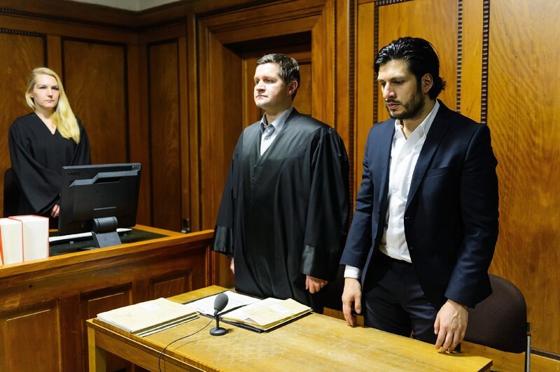 Regungslos wartet Maximilian (Francisco Medina, r.) mit seinem Anwalt Jens Meister (Martin Becker) auf die Urteilsverkündung des Richters (l. Komparsin). – Bild: RTL /​ Willi Weber