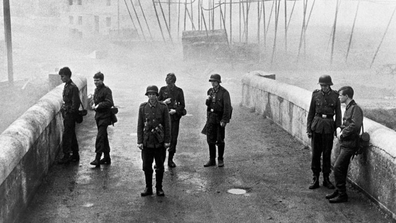 Kurz vor Ende des Zweiten Weltkriegs erhalten die unbedarften Oberschüler Hans Scholten (Folker Bohnet), Albert Mutz (Fritz Wepper), Walter Forst (Michael Hinz), Jürgen Borchert (Frank Glaubrecht), Klaus Hager (Volker Lechtenbrink), Sigi Bernhard (Günther Hoffmann) und Karl Horber (Karl Michael Balzer) den militärisch sinnlosen Auftrag, eine Brücke in ihrem Heimatort zu verteidigen. – Bild: 3sat Kurz vor Ende des Zweiten Weltkriegs erhalten die unbedarften Oberschüler Hans Scholten (Folker Bohnet), Albert Mutz (Fritz Wepper), Walter Forst (Michael Hinz), Jürgen Borchert (Frank Glaubrecht), Klaus Hager (Volker Lechtenbrink), Sigi Bernhard (Günther Hoffmann) und Karl Horber (Karl Michael Balzer) den militärisch sinnlosen Auftrag, eine Brücke in ihrem Heimatort zu verteidigen. – Bild: 3sat