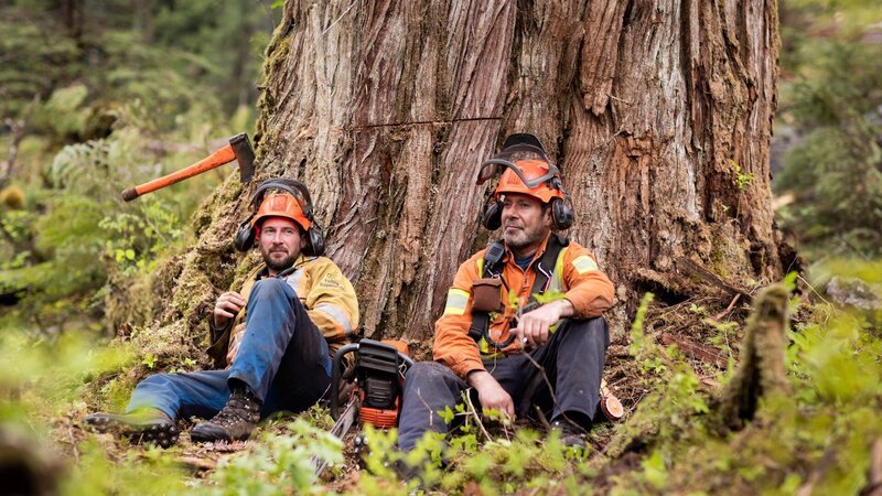 Hand Fallers Chris Hersics and Brendan Bowman take a rest beneath their latest money tree in the Pacific Northwest. – Bild: Warner Bros. Discovery