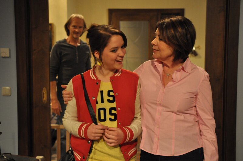 Kathi sichert Rosi ihre Verschwiegenheit zu. Von links: Sascha Wagenbauer (Eisi Gulp), Katharina Benninger (Carina Dengler) und Rosi Brunner (Brigitte Walbrun). – Bild: BR/​Jo Bischoff