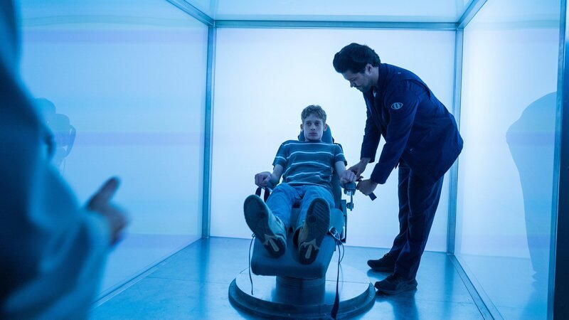 Luke (Joe Freeman, l.) wird von Tony (Jason Diaz, r.) in der „Traumbox“ festgeschnallt. Dort wartet das nächste grausame Experiment auf ihn. – Bild: ZDF
