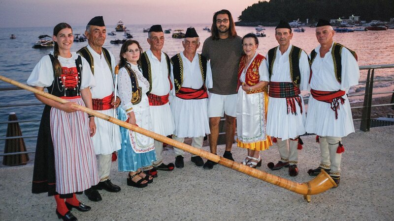 Lisa Stoll (l.) mit einer traditionellen Iso-Polyphonie-Gruppe in Albanien. – Bild: SRG SSR