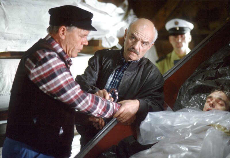 Die Ermittlungen in dem Mordfall auf dem Campingplatz nehmen eine dramatische Wendung: Als Hauptkommissar Brockmöller (Charles Brauer, rechts) Platzwart Böhlich (Peter Striebeck, links) verhaftet, fällt bei dessen Fluchtversuch die Leiche des vermissten Robert Wagner aus einem Boot. Böhlich ist schockiert, denn Wagner war sein Freund. – Bild: NDR