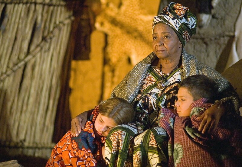 Makhulu (Nonkosi Frances Ndlazilwana), eine afrikanische Sangoma, kümmert sich um Neo (Pascal Andres) und seine Schwester Lindiwe (Ronja Forcher), die um ihren toten Vater trauern. – Bild: ARD Degeto/​Thomas Schumann